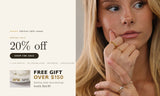 Model wearing stacked dainty gold rings with pear-cut cubic zirconia and pearl stones. Spring Sale — 20% off sitewide, free gift over $150.