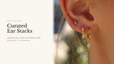 Gold marquise ear stack — cubic zirconia studs, huggie hoops and a marquise drop layered on one ear.