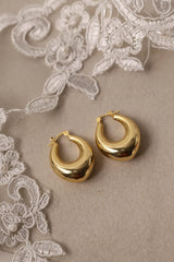 Chunky gold and silver earrings including thick hoops, dome earrings, waterdrop shapes and sculptural statement studs.