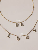 Two gold initial letter necklaces spelling out names, in waterproof stainless steel