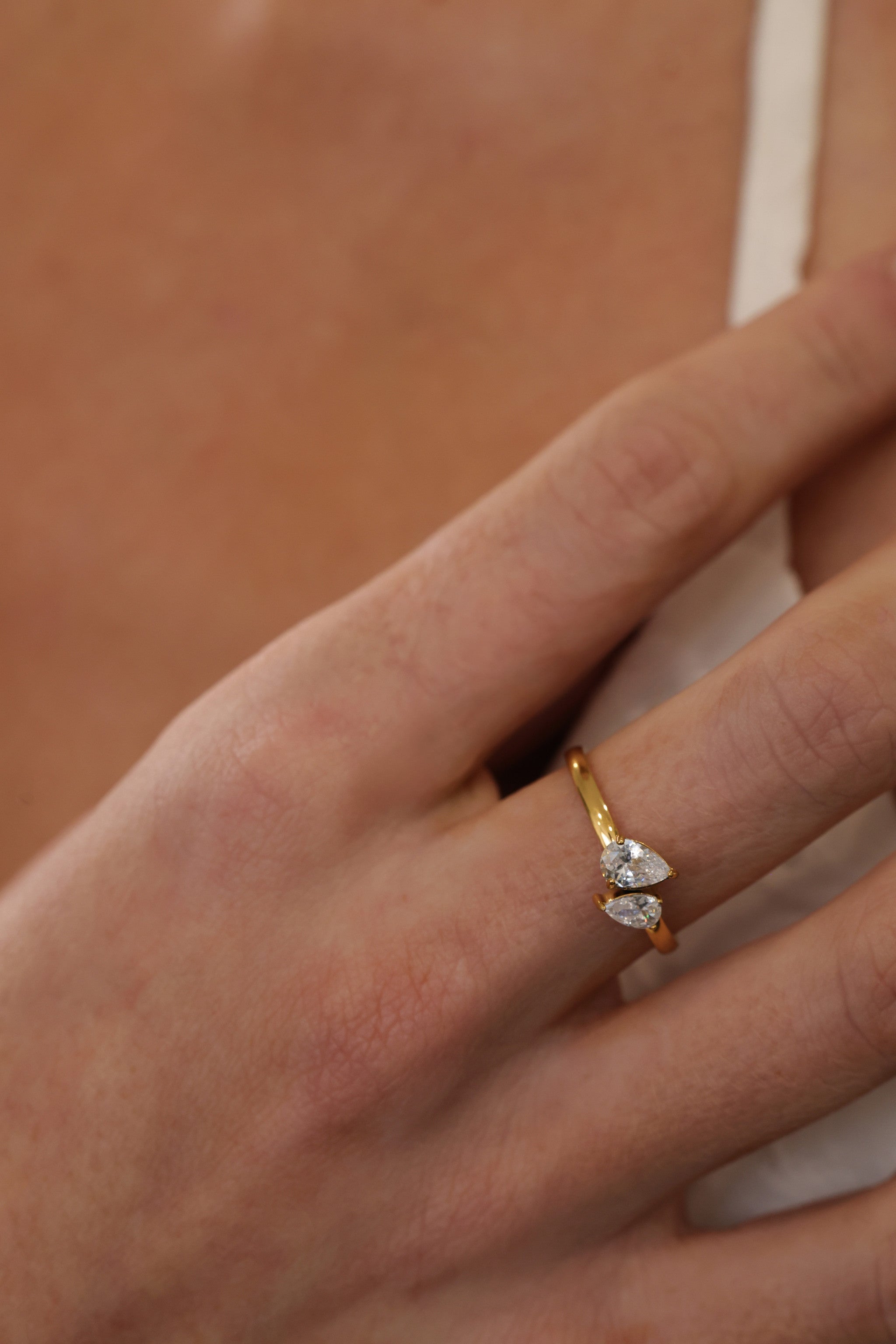 Elodie toi et moi pear ring in gold worn on a model's finger, close view