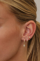 Sara gold ear stack shown wider on the ear — drop huggie, pave huggie and marquise stud