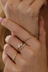 Eloise pear solitaire ring worn stacked with a pearl band in gold