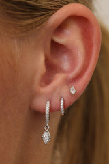 Sara sterling silver three-piece ear stack worn on one ear — drop huggie, pave huggie and stud