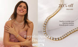 A promotional jewelry listing split into two sections: on the left, a smiling woman in a pink dress wears a delicate gold necklace and bracelet; on the right, a close-up shows a gold tennis-style necklace with clear rhinestones. Text overlays read '20% off Sitewide', 'Everyday Sparkle Elevated', and 'Shop Best Sellers'.
