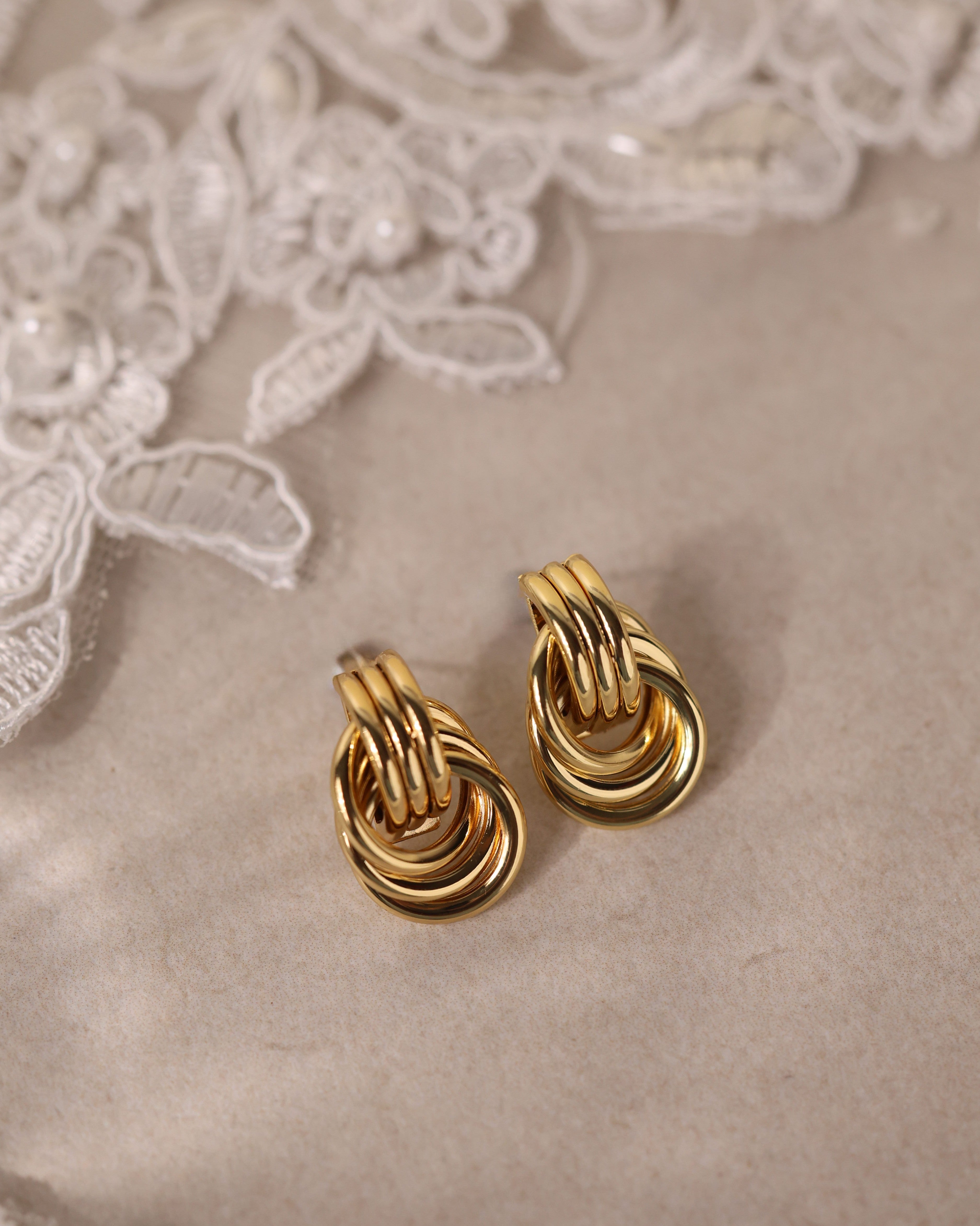 gold interlocking ring earrings with a polished knot design that reflects light beautifully.