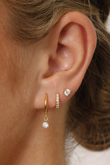 A three‑pair 18k gold‑plated sterling silver earring set featuring a delicate CZ dangle earring, a classic 7mm CZ huggie, and a tiny 3mm CZ stud. The set includes high‑grade cubic zirconia stones and polished gold finishes, styled together for a refined, minimal look.