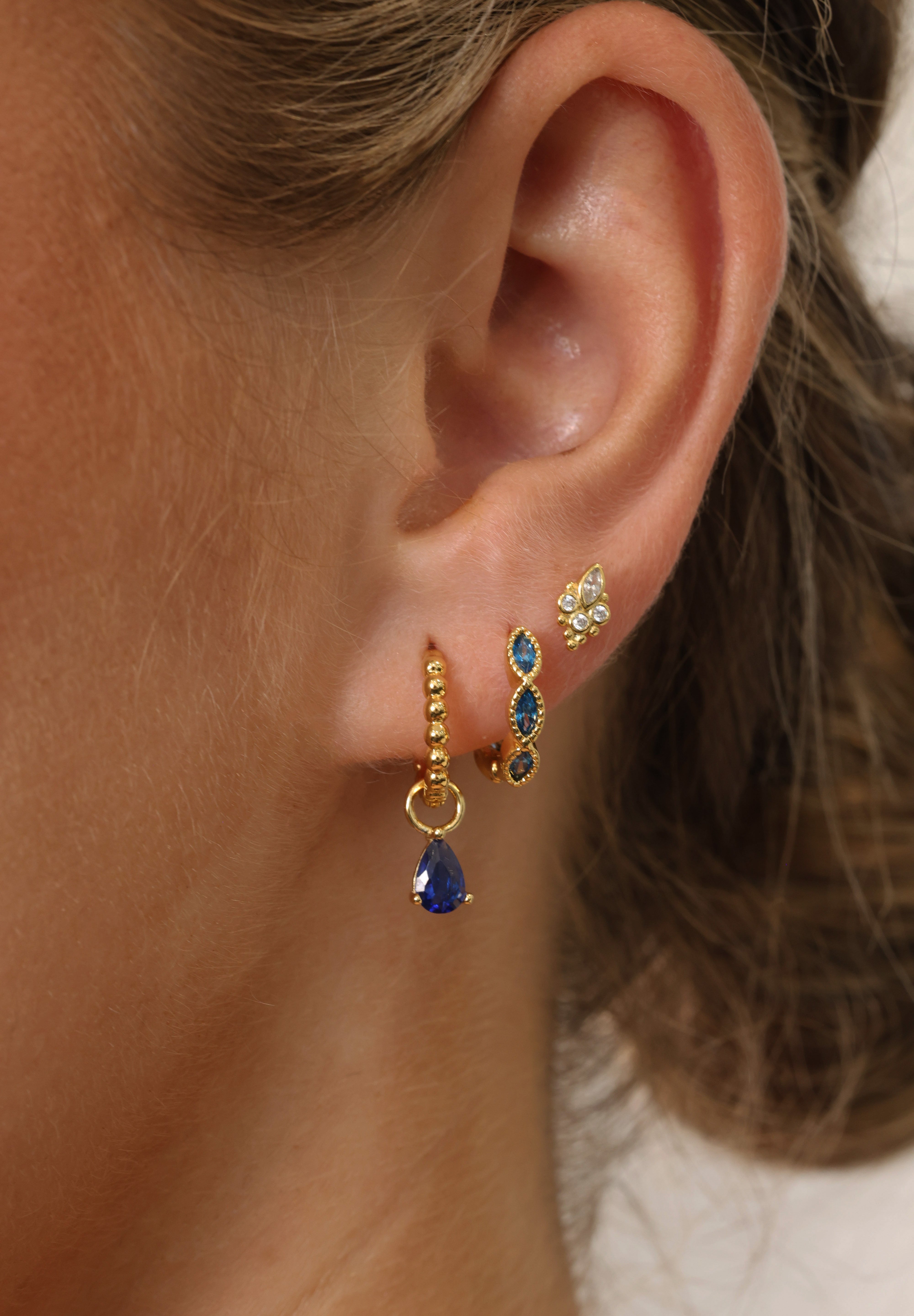 Add a touch of colour and elegance with these Blue Marquise Hoop Earrings, crafted from 925 sterling silver and finished in a rich 18k gold plating. The faceted marquise‑cut stones catch the light beautifully, creating a soft, eye‑catching sparkle perfect for everyday wear or special occasions. Lightweight, comfortable, and designed for effortless stacking.