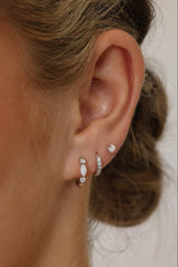 White Gold‑plated sterling silver opal huggie hoop earrings with shimmering opal inlays, shown for a soft, elegant, iridescent look.