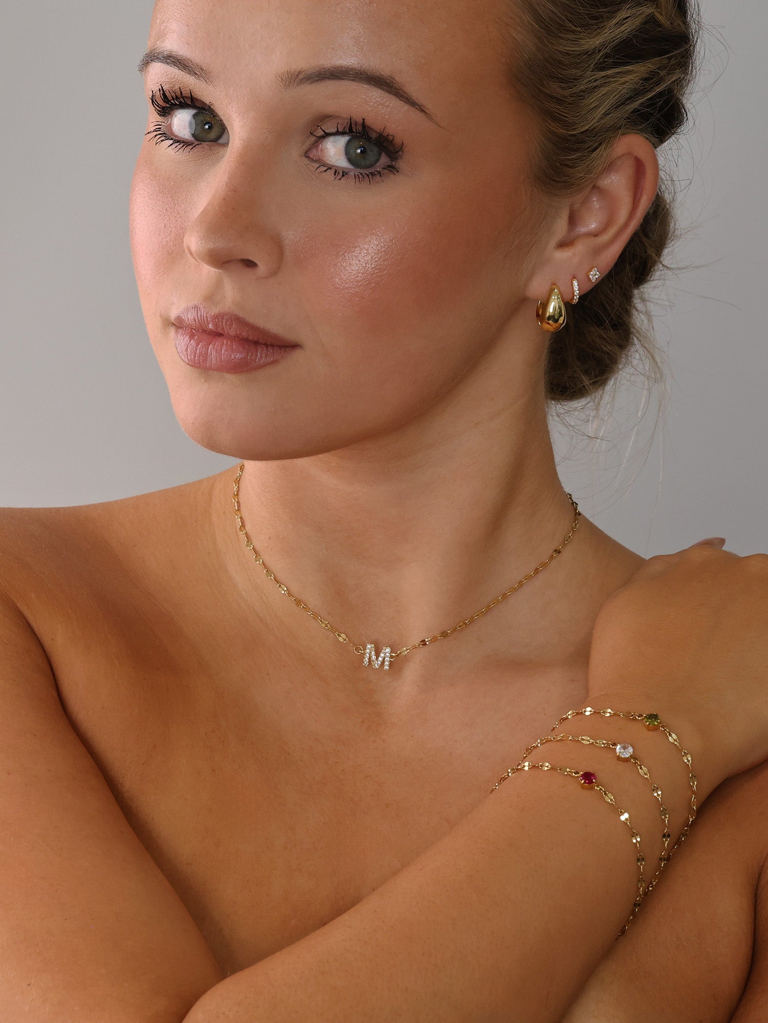 Gold stainless steel birthstone bracelet with a dainty chain and a single bezel‑set gemstone charm hanging at the centre.