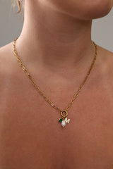 Gold stainless steel necklace with pearl, green birthstone charm, and crystal initial charm on an easy‑open hook.