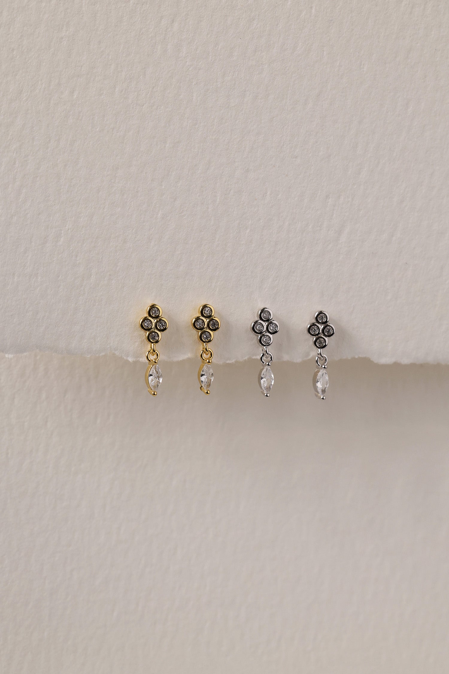 A delicate pair of dangle stud earrings with a refined, light‑catching drop. Crafted in rhodium‑plated 925 sterling silver with premium AAAAA cubic zirconia, they offer timeless sparkle for everyday wear or special occasions.