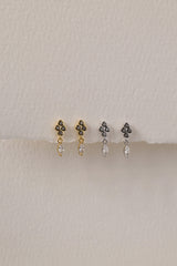 A delicate pair of dangle stud earrings with a refined, light‑catching drop. Crafted in rhodium‑plated 925 sterling silver with premium AAAAA cubic zirconia, they offer timeless sparkle for everyday wear or special occasions.