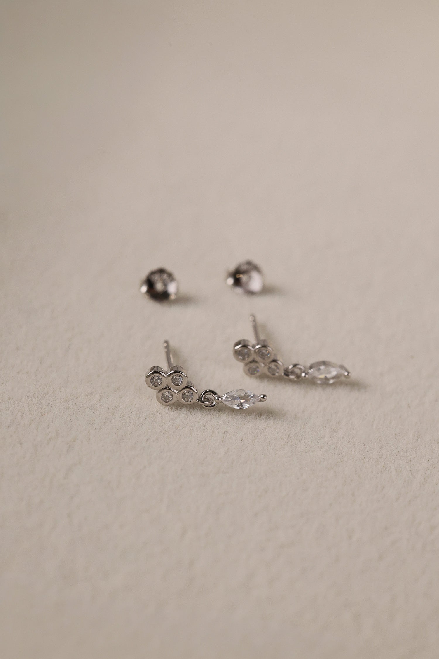 A delicate pair of dangle stud earrings with a refined, light‑catching drop. Crafted in rhodium‑plated 925 sterling silver with premium AAAAA cubic zirconia, they offer timeless sparkle for everyday wear or special occasions.