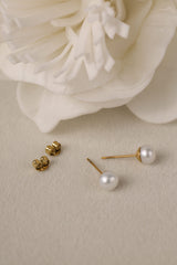 Small freshwater pearl stud earring worn on the earlobe, shown in a gold stainless steel setting.