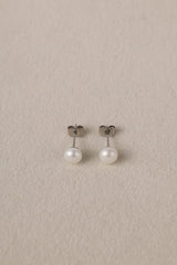 Small freshwater pearl stud earring worn on the earlobe, shown in a gold stainless steel setting.