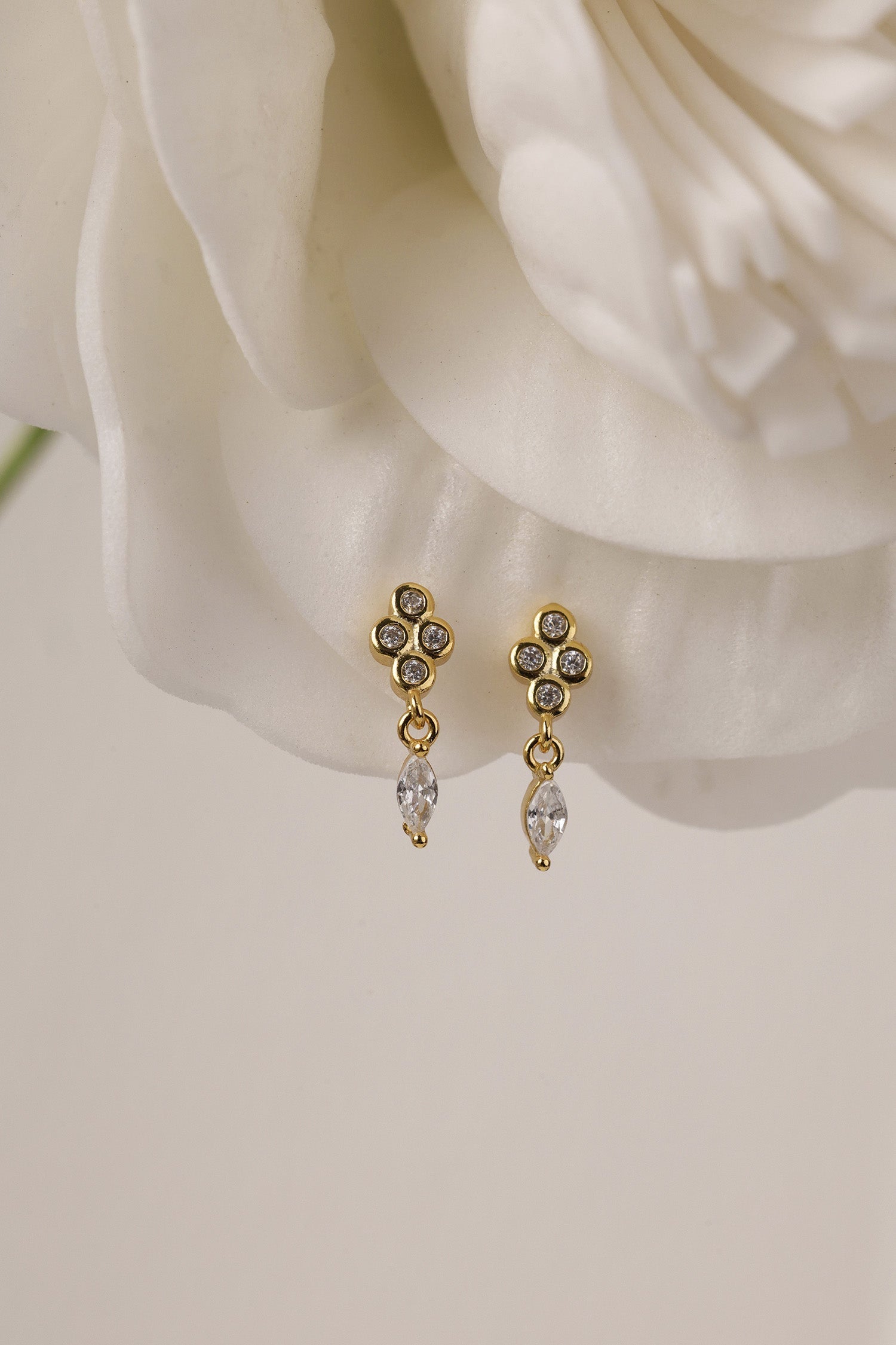 Pair of Nova gold drop earrings — three bezel-set stones above a marquise drop