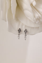 A delicate pair of dangle stud earrings with a refined, light‑catching drop. Crafted in rhodium‑plated 925 sterling silver with premium AAAAA cubic zirconia, they offer timeless sparkle for everyday wear or special occasions.