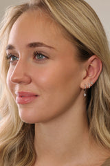 A sterling silver three‑piece earring set featuring a CZ dangle earring, a small CZ huggie, and a delicate teardrop‑shaped stud. Each piece is rhodium‑plated 925 sterling silver with brilliant AAAAA cubic zirconia, designed for a sparkling, elegant look.