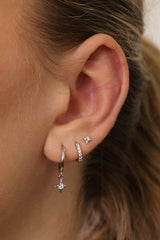 A three‑pair celestial gold earring set featuring a star stud, a moon‑shaped huggie, and a sparkling dangle charm, displayed together for an elegant, versatile look.