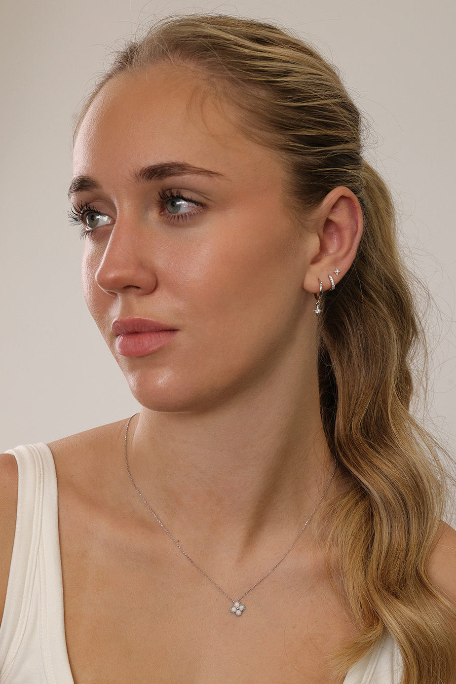 A three‑pair celestial silver earring set featuring a star stud, a moon‑shaped huggie, and a sparkling dangle charm, displayed together for an elegant, versatile look.