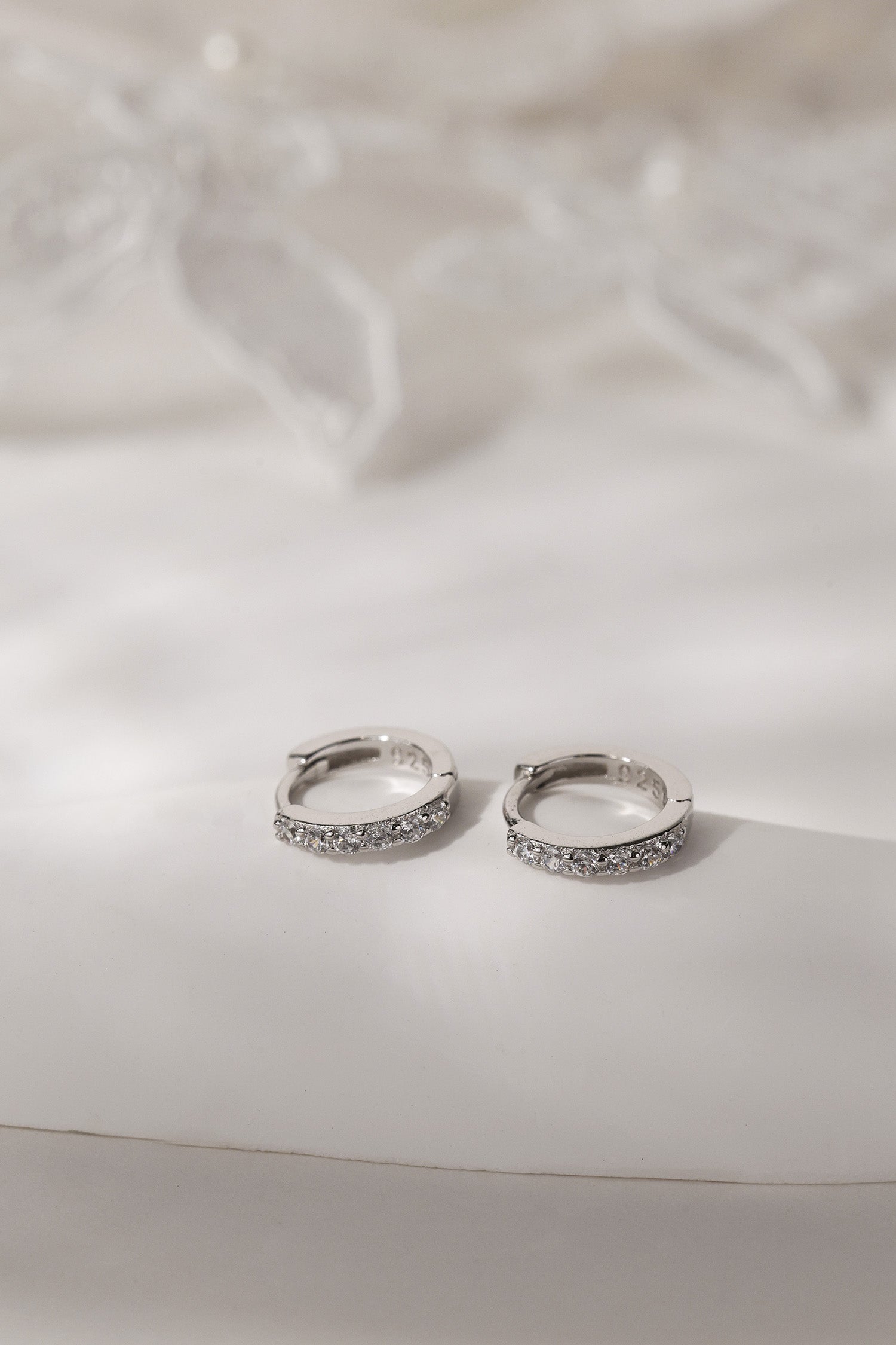 A three‑pair celestial silver earring set featuring a star stud, a moon‑shaped huggie, and a sparkling dangle charm, displayed together for an elegant, versatile look.