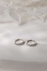 A three‑pair celestial silver earring set featuring a star stud, a moon‑shaped huggie, and a sparkling dangle charm, displayed together for an elegant, versatile look.