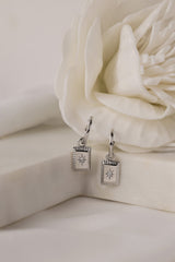 Sterling silver starburst rectangle drop earring with CZ stone on ear — ANETT Jewellery