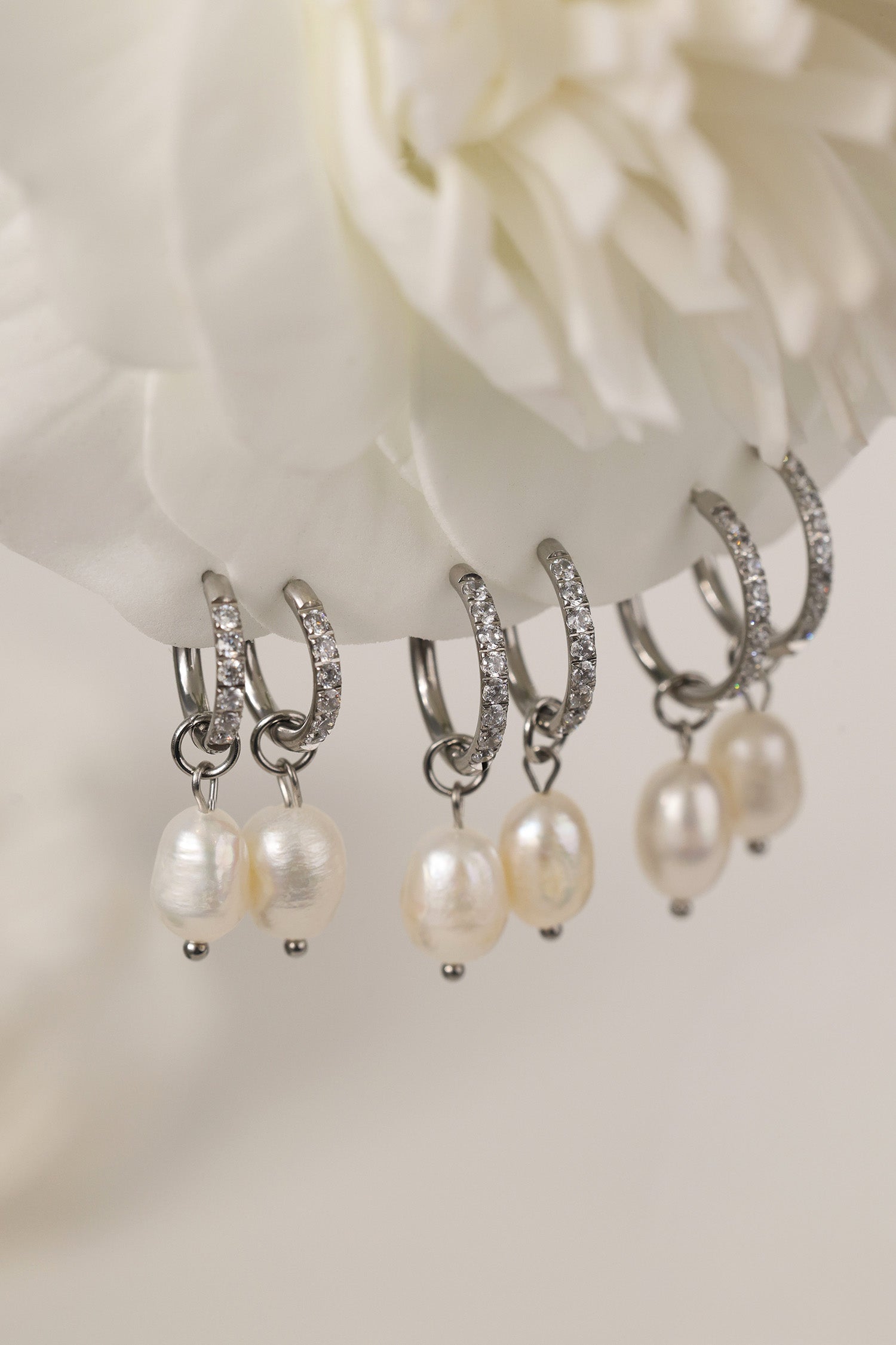 Waterproof pavé hoop earrings with natural freshwater pearl drops. Available in 10mm, 12mm, and 14mm. Tarnish‑resistant, elegant, and perfect for everyday wear.
