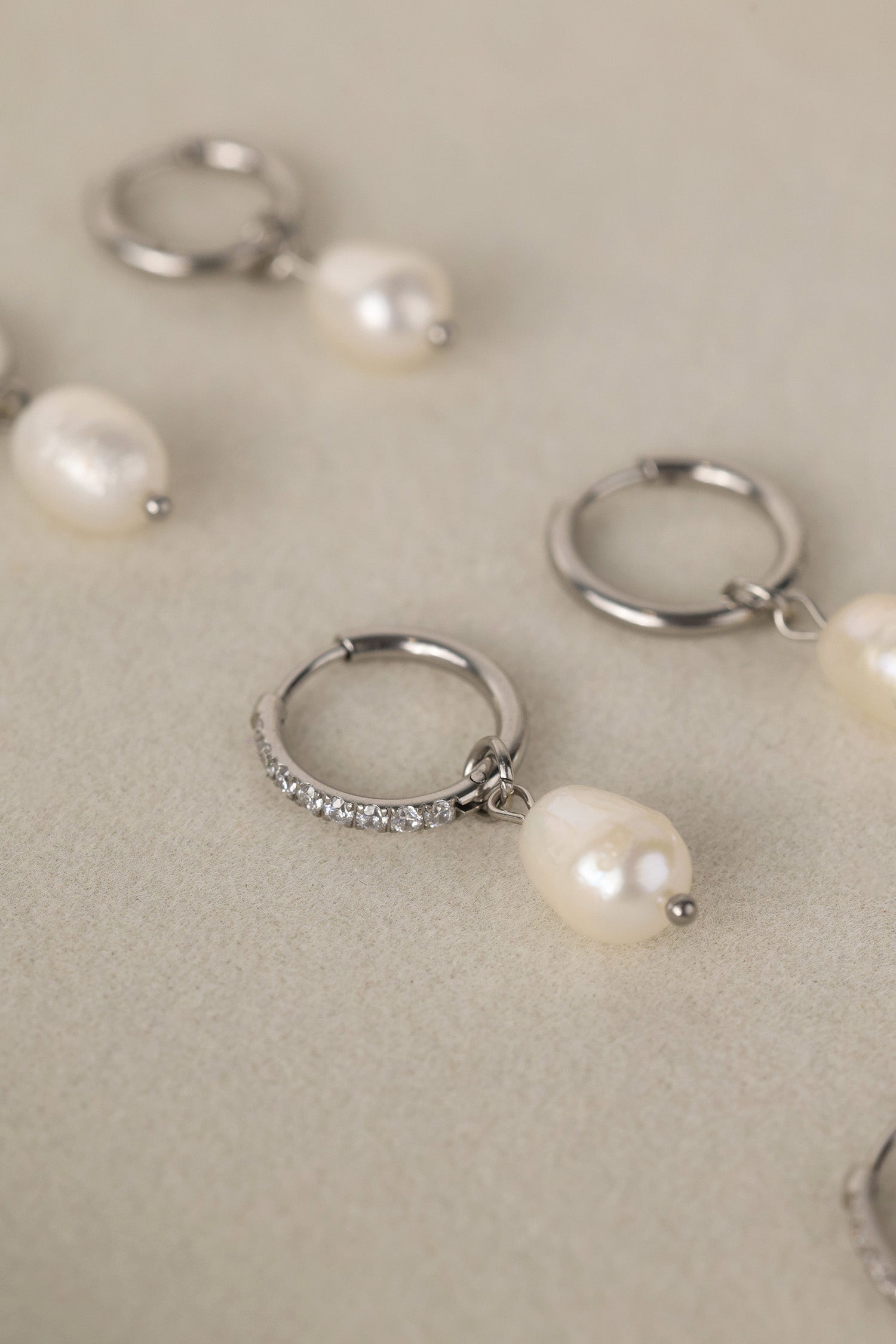 Waterproof pavé hoop earrings with natural freshwater pearl drops. Available in 10mm, 12mm, and 14mm. Tarnish‑resistant, elegant, and perfect for everyday wear.