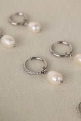 Waterproof pavé hoop earrings with natural freshwater pearl drops. Available in 10mm, 12mm, and 14mm. Tarnish‑resistant, elegant, and perfect for everyday wear.