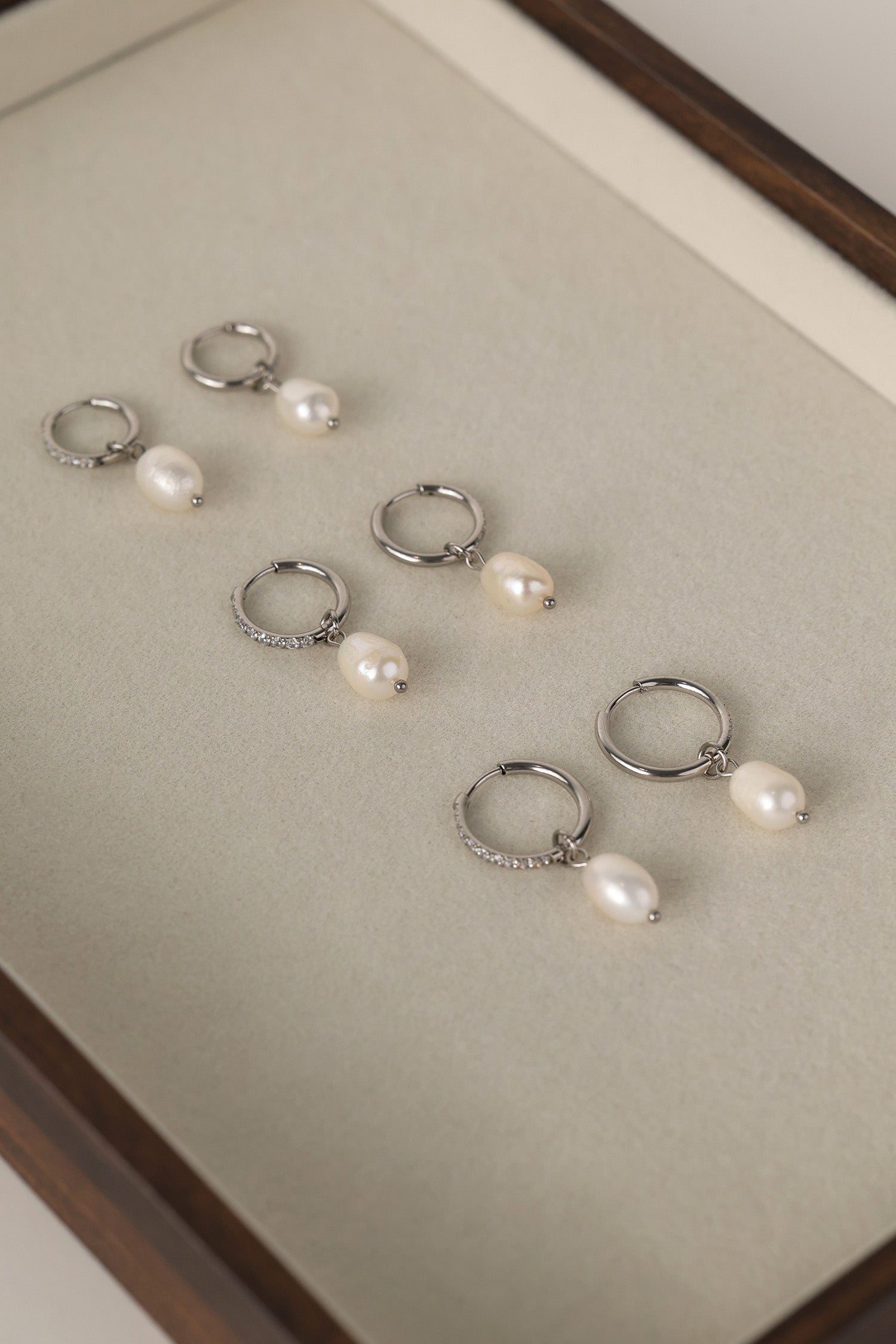 Waterproof pavé hoop earrings with natural freshwater pearl drops. Available in 10mm, 12mm, and 14mm. Tarnish‑resistant, elegant, and perfect for everyday wear.