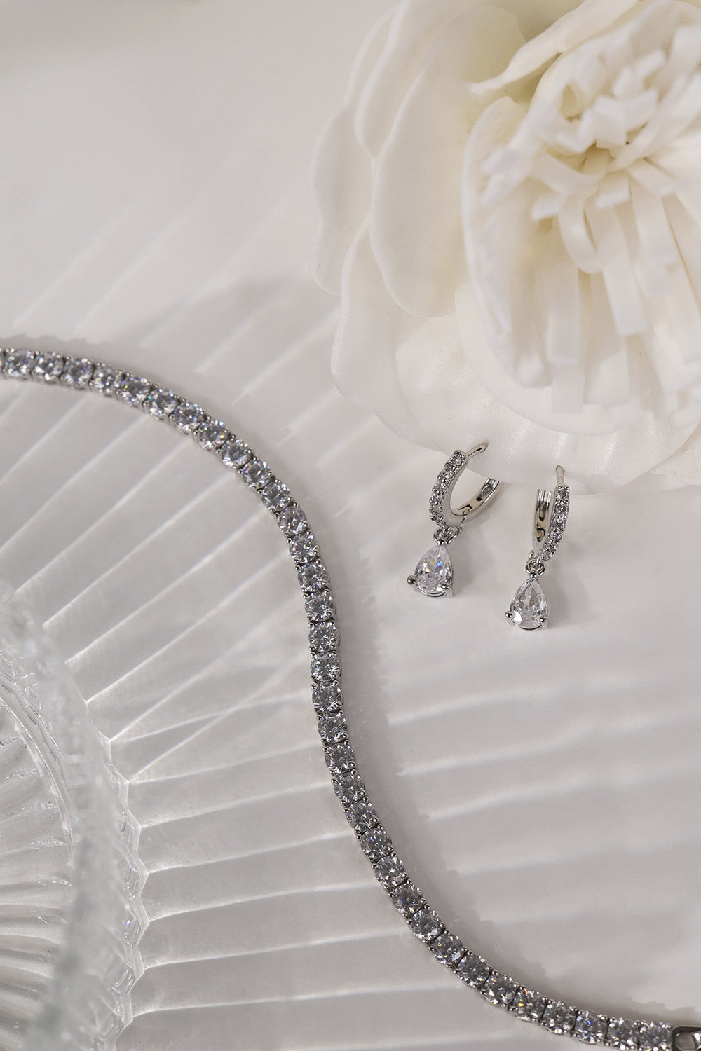 Silver Lanette tennis bracelet shown with silver diamond drop earrings.