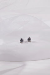 Pair of small silver round cubic zirconia stud earrings resting on white tulle.