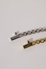 Close-up of the silver bracelet clasp engraved with the ANETT brand name, alongside the gold version.