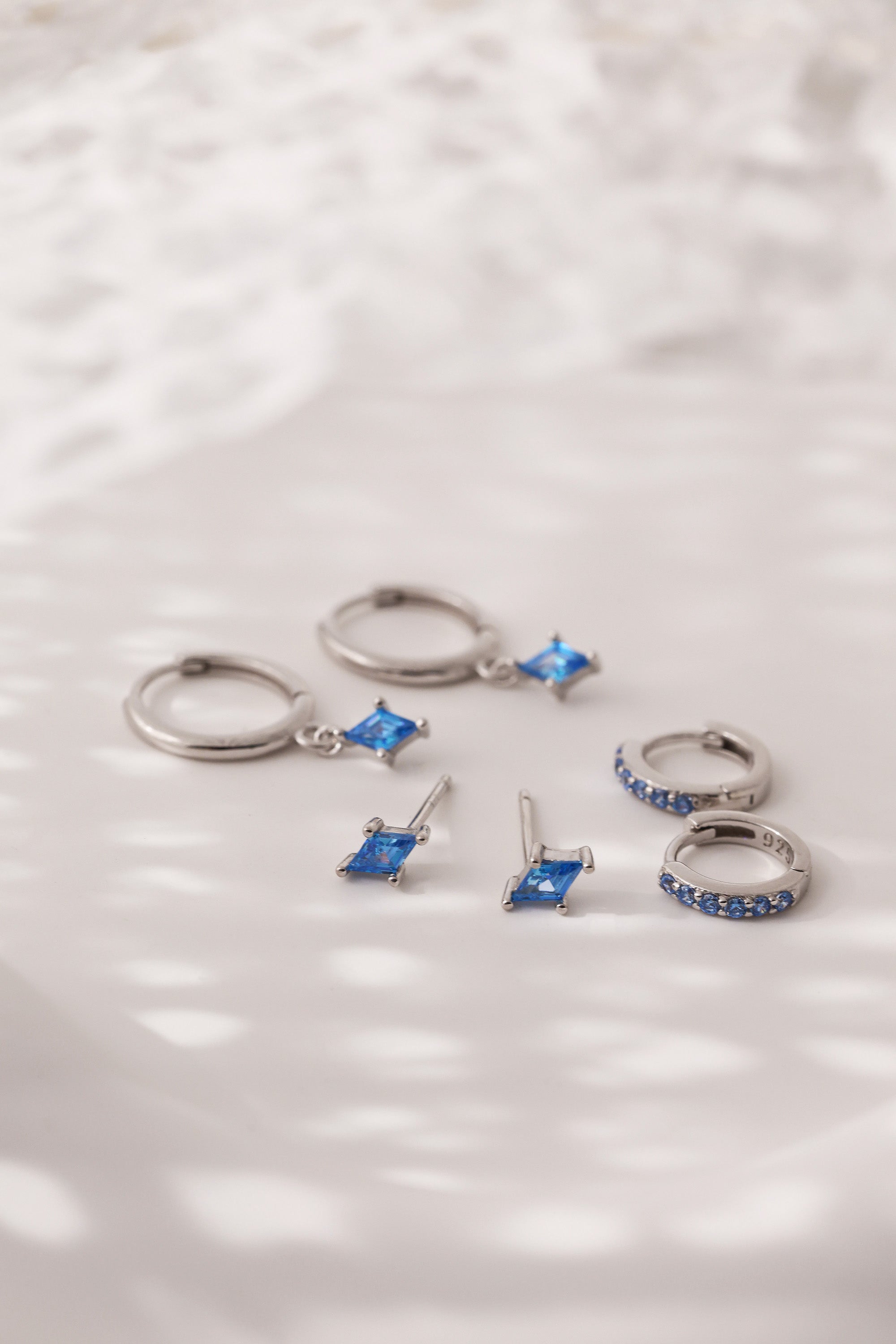Mia Blue Huggie Dangle Earrings in Sterling Silver – rhodium-plated hoops with blue cubic zirconia, hypoallergenic dainty silver earrings for women, available individually or as part of 3-pair earring stack set