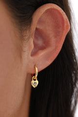 Gold hoop earrings featuring dainty heart-shaped charms, crafted in 18K gold-plated sterling silver—elegant, lightweight, and perfect for everyday sparkle or romantic layering.
