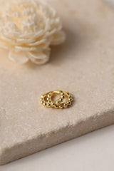 Sterling silver beaded hoop earrings in 8mm and 9mm sizes, featuring polished spherical detailing for a dainty, minimalist look. Displayed on a neutral textured surface with soft floral accents.