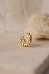 Sterling silver beaded hoop earrings in 8mm and 9mm sizes, featuring polished spherical detailing for a dainty, minimalist look. Displayed on a neutral textured surface with soft floral accents.