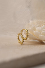 Sterling silver beaded hoop earrings in 8mm and 9mm sizes, featuring polished spherical detailing for a dainty, minimalist look. Displayed on a neutral textured surface with soft floral accents.