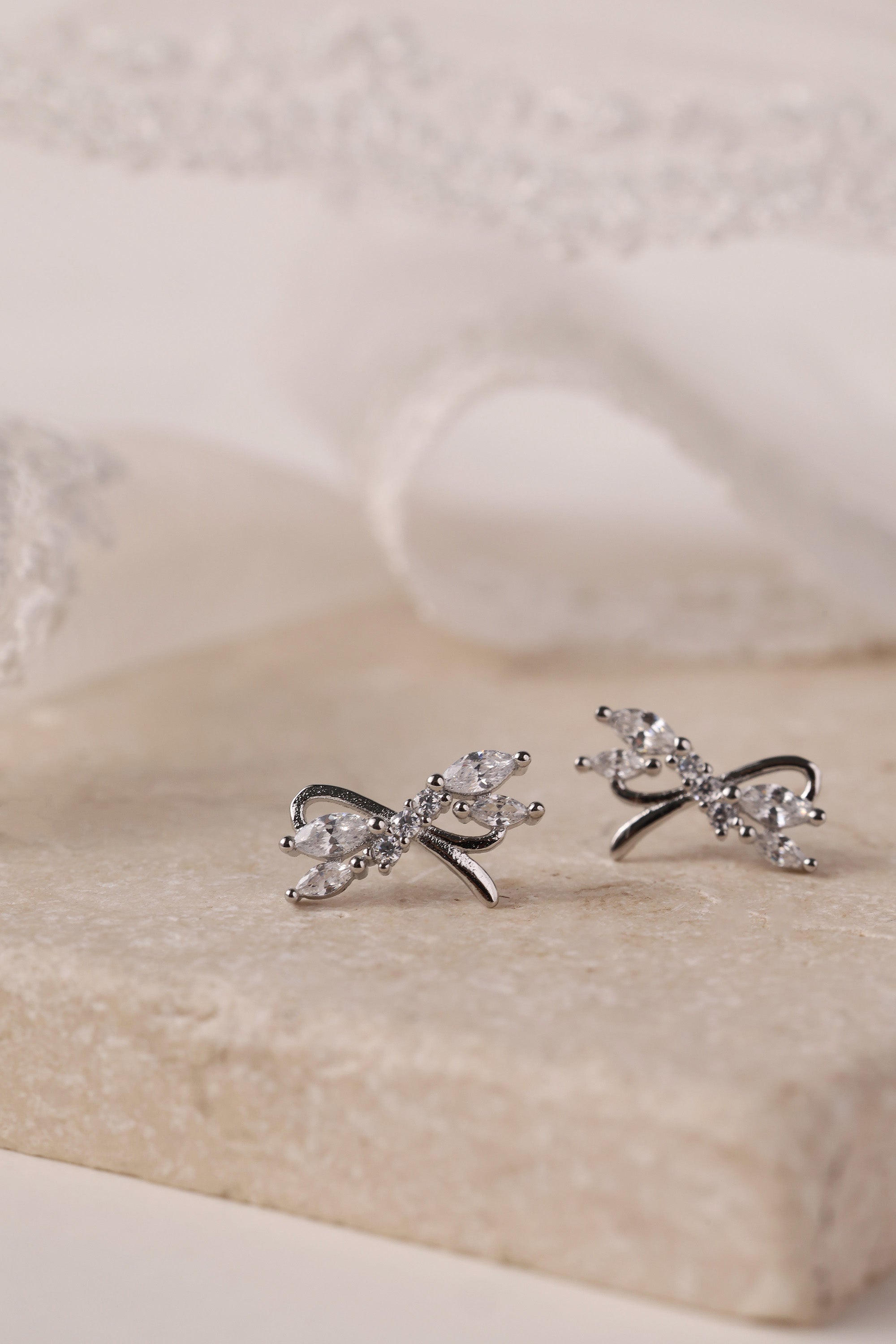 Silver stud earrings with tied ribbon detailing, 13mm wide by 7.5mm high, elegant for daily or special wear