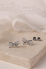 Silver stud earrings with tied ribbon detailing, 13mm wide by 7.5mm high, elegant for daily or special wear