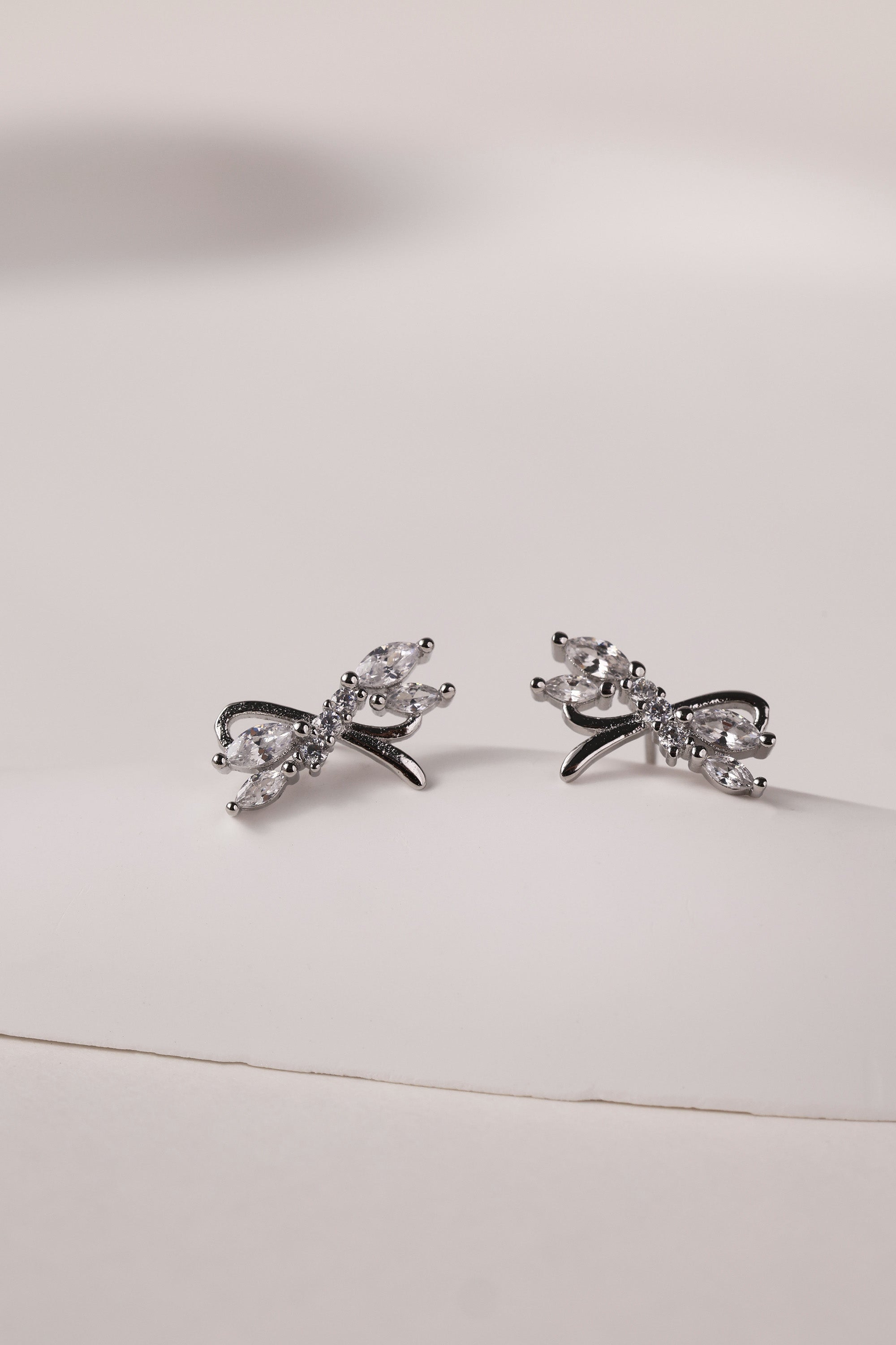 Silver stud earrings with tied ribbon detailing, 13mm wide by 7.5mm high, elegant for daily or special wear
