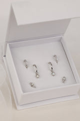 The full silver Dainty Opal set in a white ANETT gift box — opal dangle huggies, pavé huggies and opal studs.