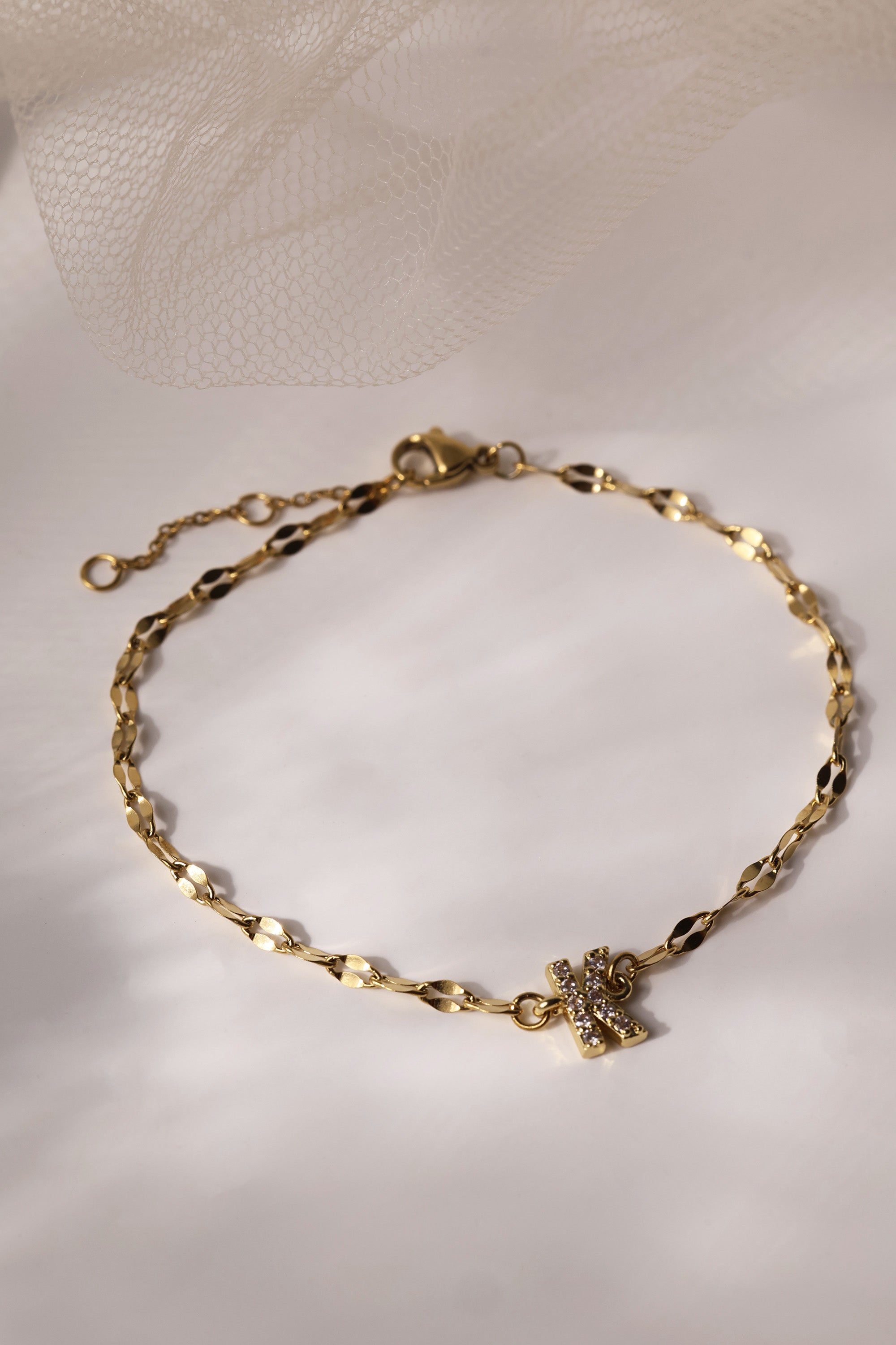 Dainty 18K gold-plated stainless steel bracelet with a single personalised initial charm, symbolising elegance and meaningful style.