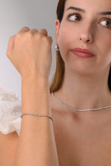 Skinny 2.5mm stainless steel tennis necklace with sparkling stones, waterproof design, casual yet elegant, paired with matching bracelet.