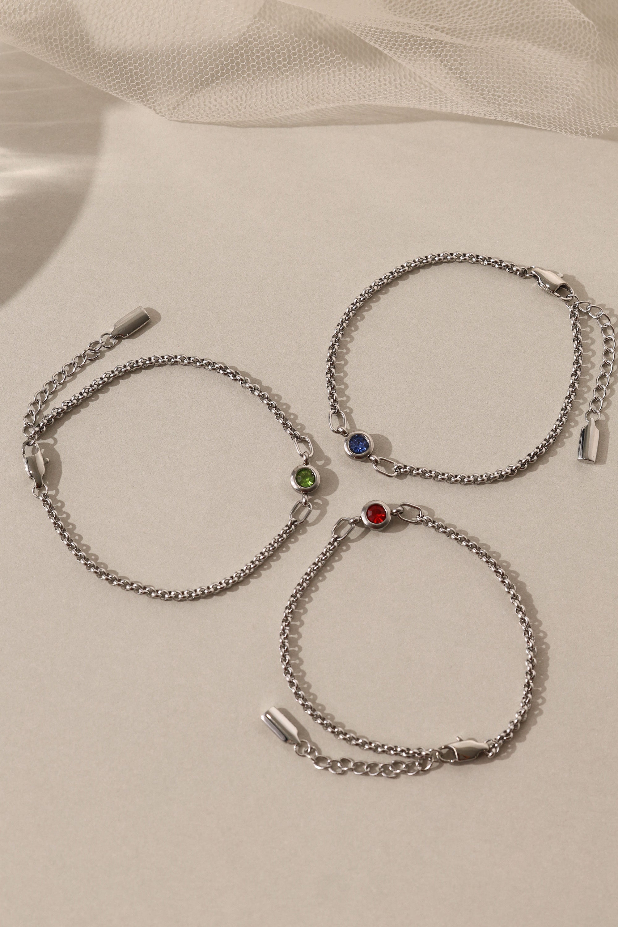 Dainty white gold-plated stainless steel birthstone bracelet with a single bezel-set gemstone, symbolizing personal meaning and everyday elegance.