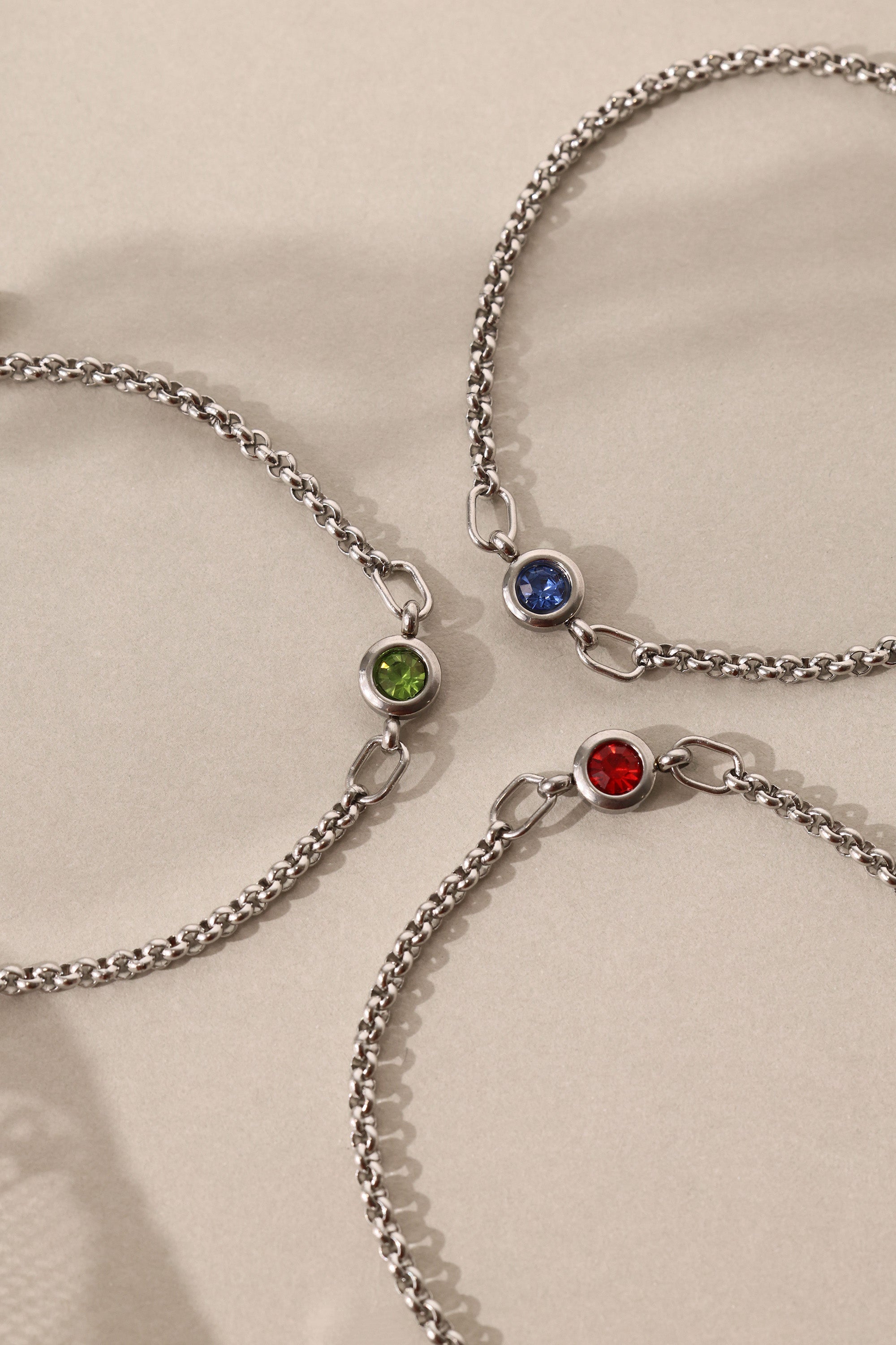 Dainty white gold-plated stainless steel birthstone bracelet with a single bezel-set gemstone, symbolizing personal meaning and everyday elegance.