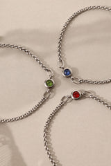 Dainty white gold-plated stainless steel birthstone bracelet with a single bezel-set gemstone, symbolizing personal meaning and everyday elegance.
