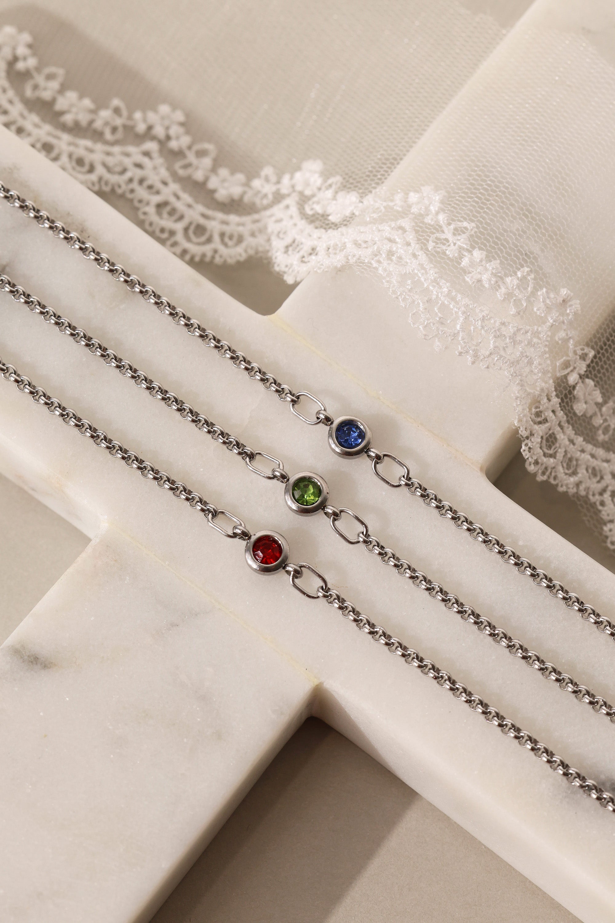 Dainty white gold-plated stainless steel birthstone bracelet with a single bezel-set gemstone, symbolizing personal meaning and everyday elegance.